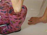 Schlüpfe in wasser gefüllte Wellies im Lila Badeanzug in der Dusche