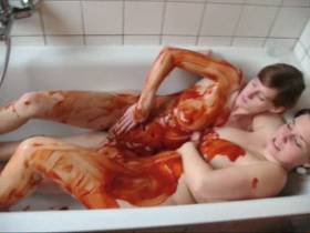 Two lesbians bathing in ketchup