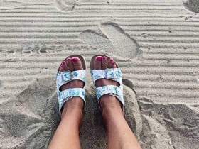 Feet in slippers on the beach