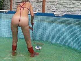 In red rubber boots and a red mini bikini in the pool