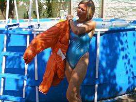 Christina in einem Pool in Moncler Daunenjacke und Realise Gummi-Badeanzug