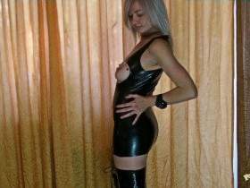 Christina posing in Latex Mini Dress and high boots