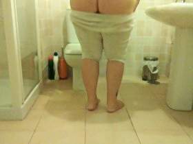 She is pissing on the bathroom floor