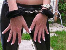 Posing outdoors with handcuffs in slinkystylez leggings