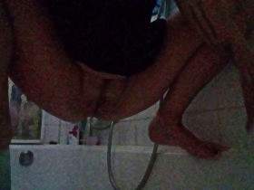 Crouching over the bathtub