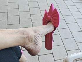 Dangling and shoeplay outdoors with fuchsia mules
