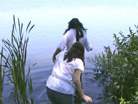 Two lesbians swim dressed in the lake