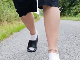 In Latschen und weißen Socken in der Natur