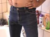 Mann pinkelt in Jeans und duscht