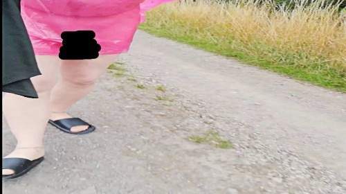 In Regencape, Strumpfhose und Latschen im Nieselregen